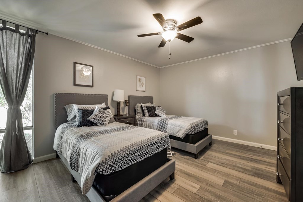 a bedroom with two beds and a ceiling fan