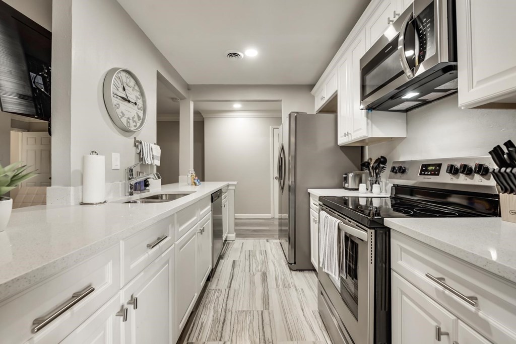 a kitchen with white cabinets and stainless steel appliances