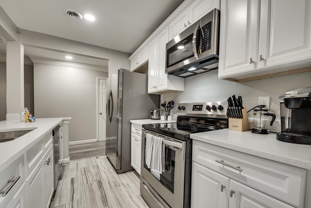 a kitchen with white cabinets and stainless steel appliances