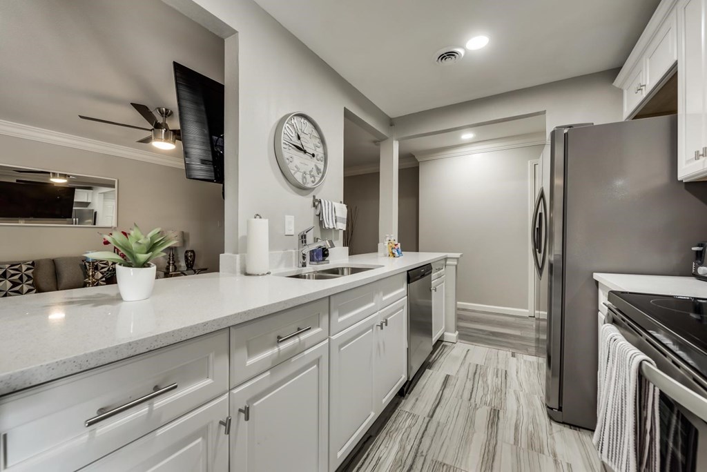a kitchen with white cabinets and stainless steel appliances