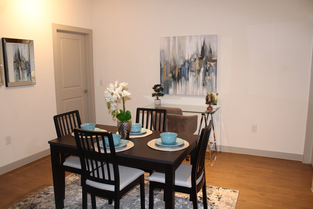 a dining room with a table and chairs and a painting on the wall