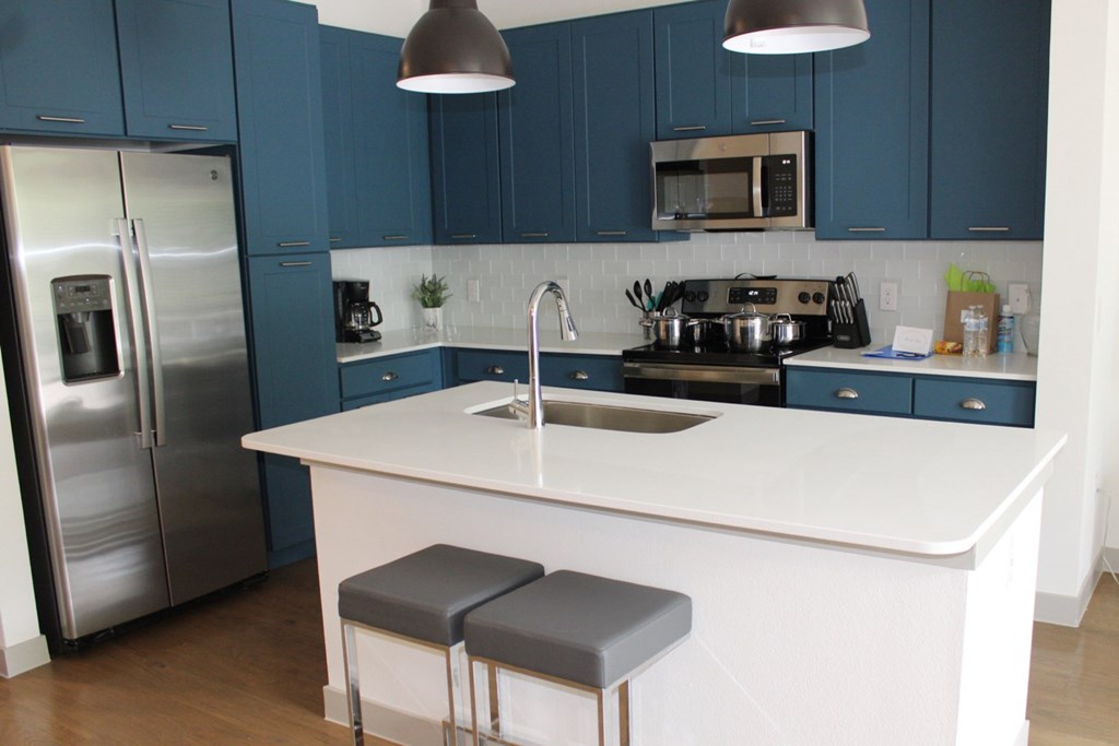 a kitchen with blue cabinets and a white counter top