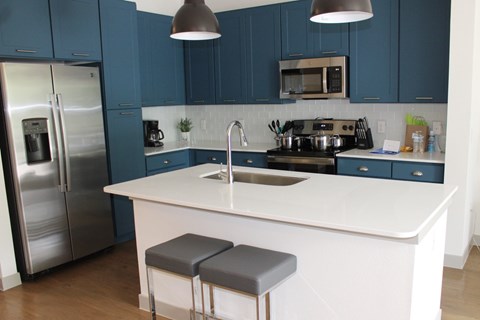 a kitchen with blue cabinets and a white counter top