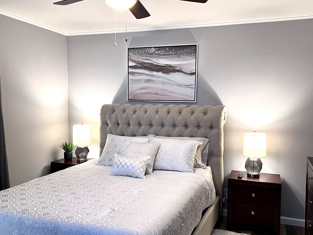 a bedroom with a bed and a painting on the wall