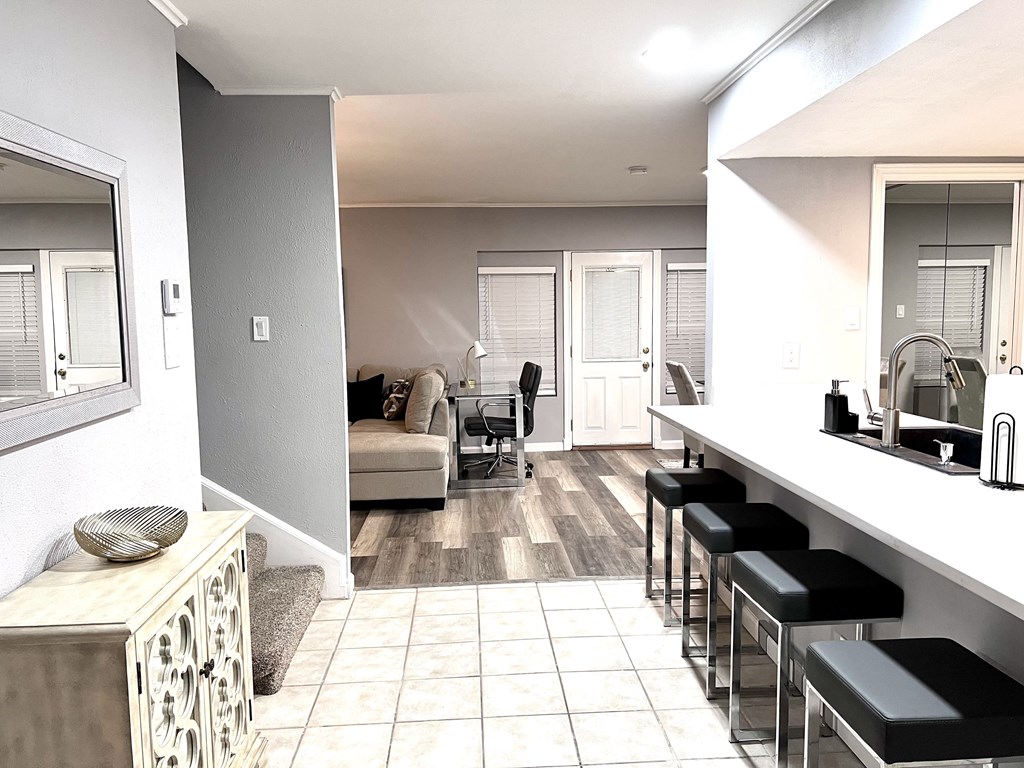 a view of a kitchen and living room with a bar and stools