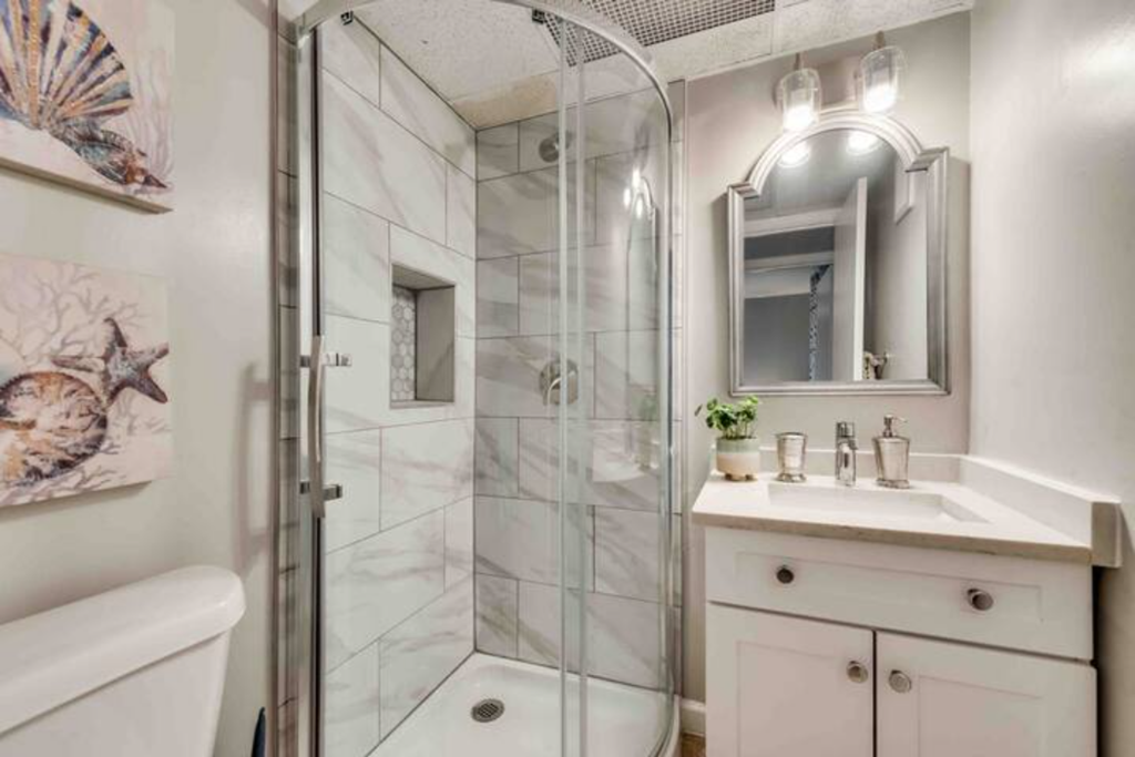 a bathroom with a shower and a sink and a mirror