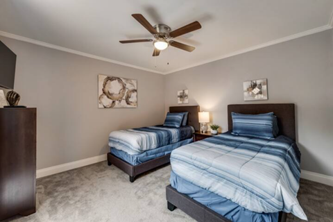 a bedroom with two twin beds and a ceiling fan