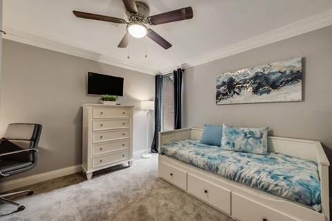 a bedroom with a bed and a ceiling fan