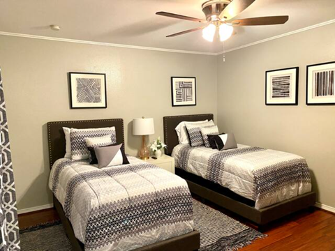 a bedroom with two beds and a ceiling fan