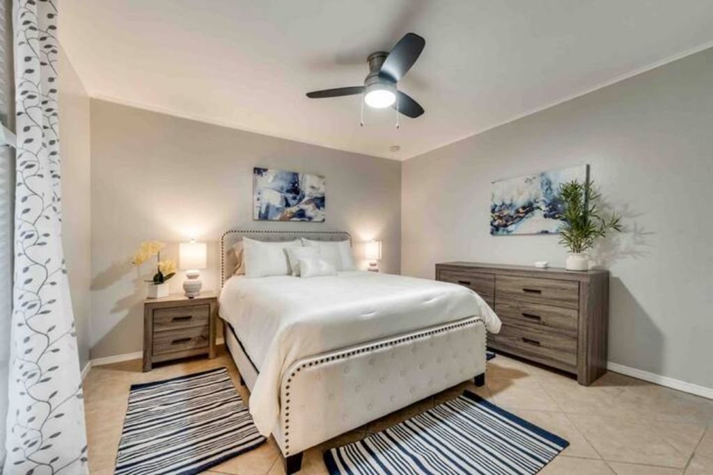 a bedroom with a bed and a ceiling fan