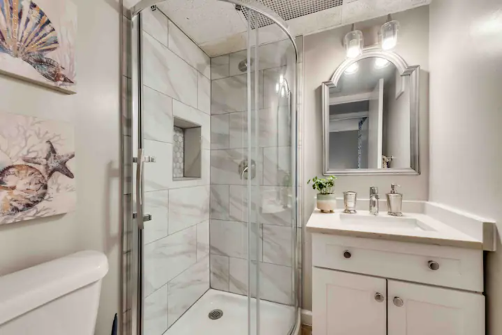 a bathroom with a shower and a sink and a mirror