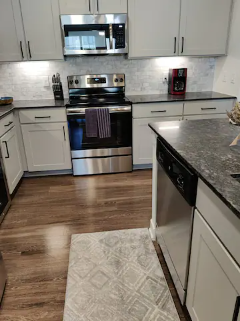 a kitchen with white cabinets and stainless steel appliances