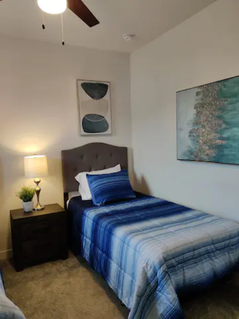 a bedroom with a bed and a painting on the wall