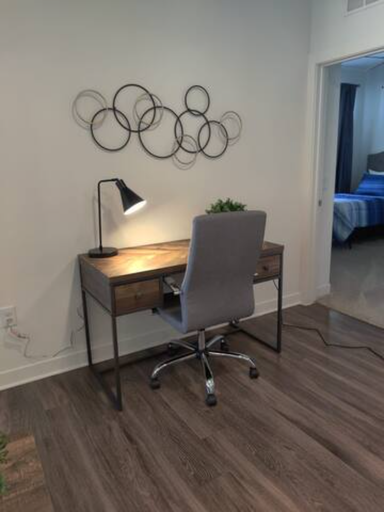 a desk with a chair and a lamp in a room