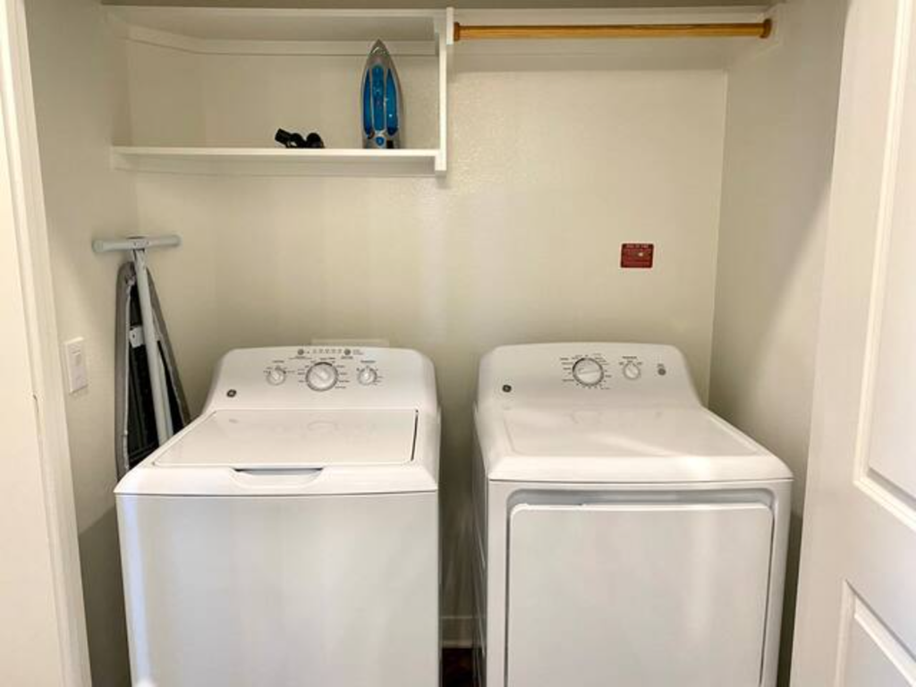 two washers and a dryer in a white room