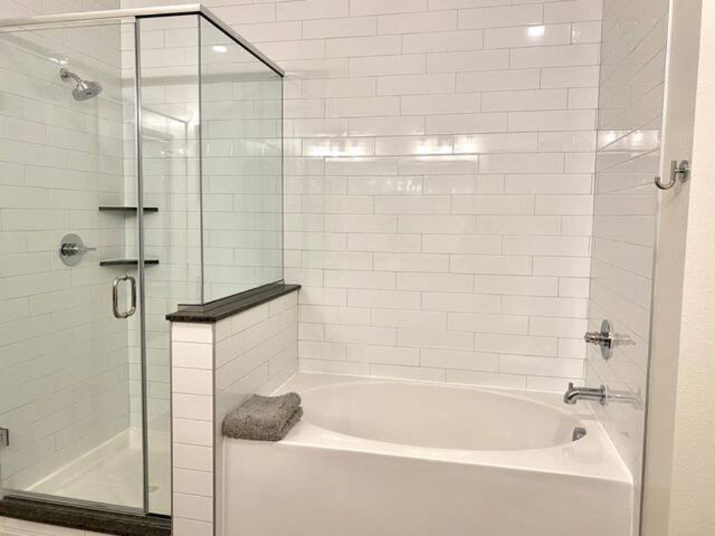 a white bathroom with a tub and a shower