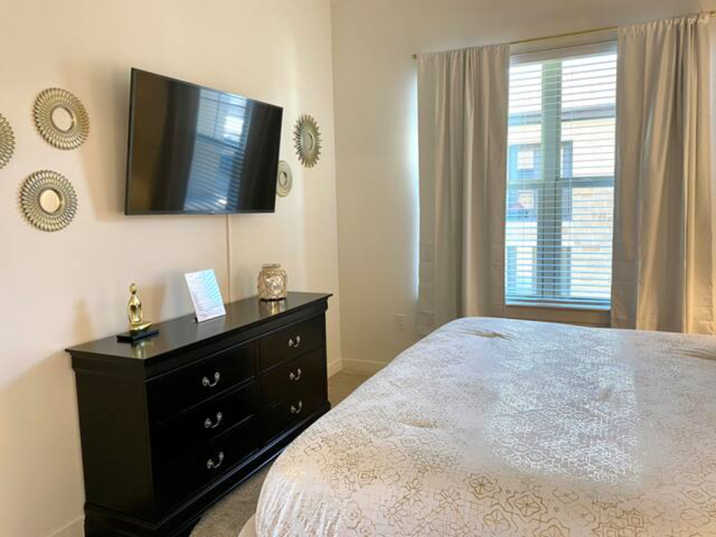 a bedroom with a bed and a tv on the wall