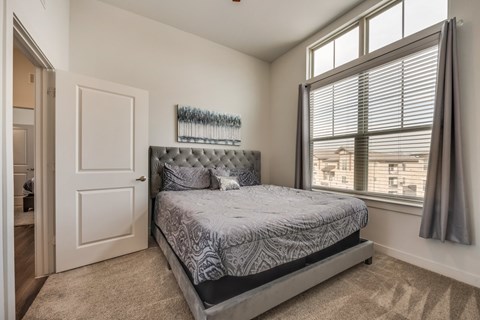 a bedroom with a bed and a large window