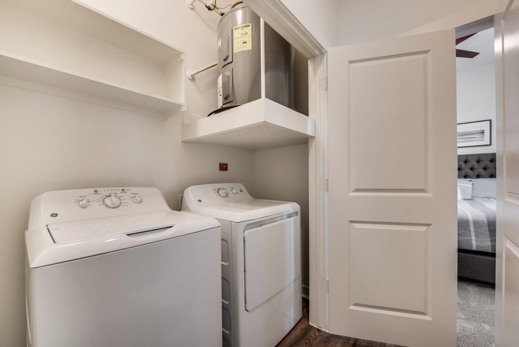 a washer and dryer in a laundry room with a door to a bedroom