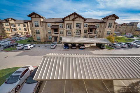 an overhead view of an apartment complex with cars parked in the parking lot