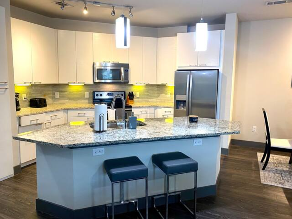 a kitchen with a counter with three stools