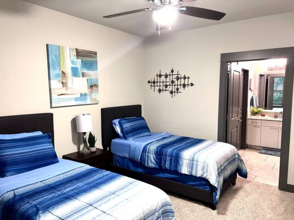 a bedroom with two beds and a ceiling fan
