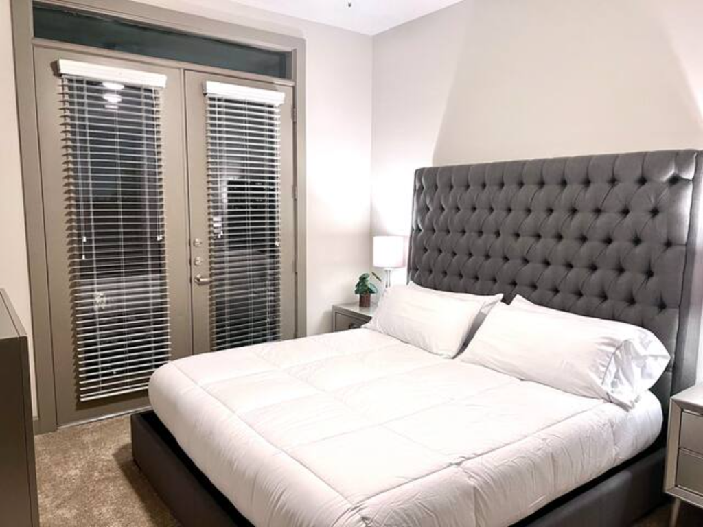 a bedroom with a bed and a large window