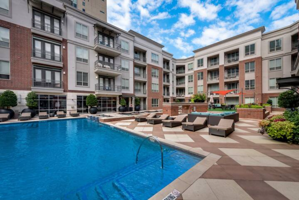 a large swimming pool in front of an apartment building
