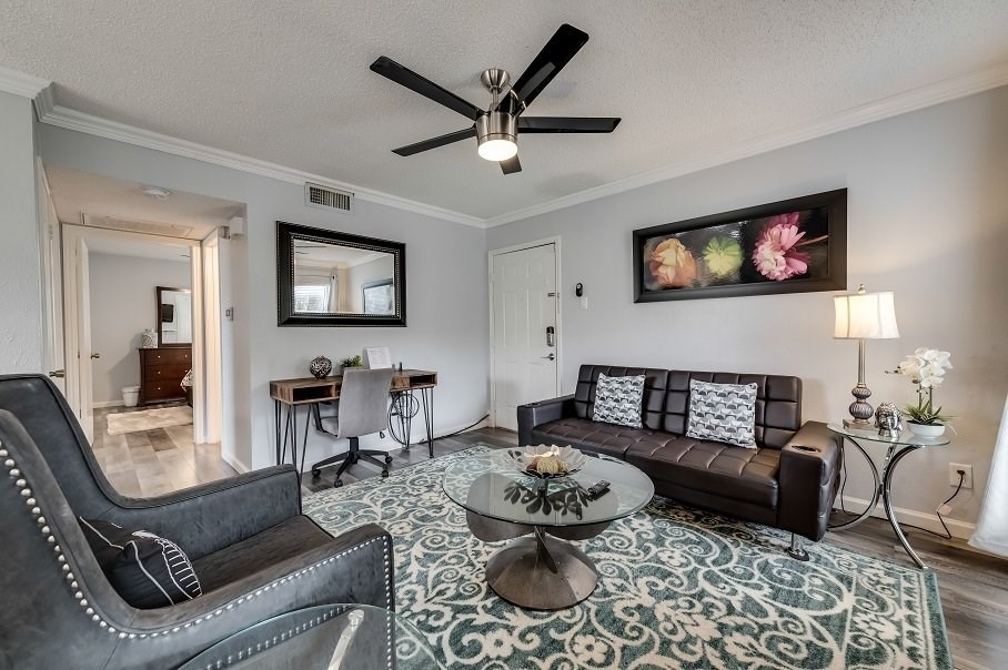 a living room with furniture and a ceiling fan