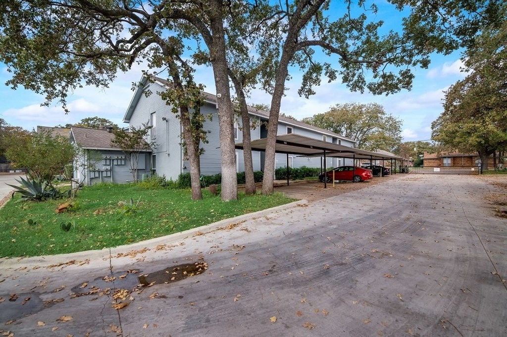 a house with a driveway and trees in front of it