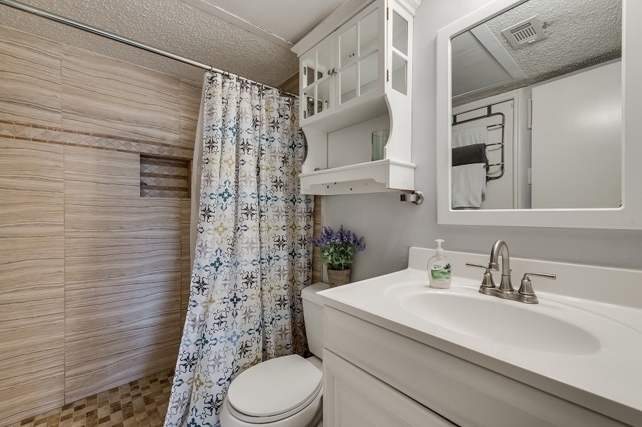 a bathroom with a shower curtain and a toilet and a sink