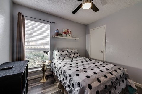 a bedroom with a black and white bed and a window