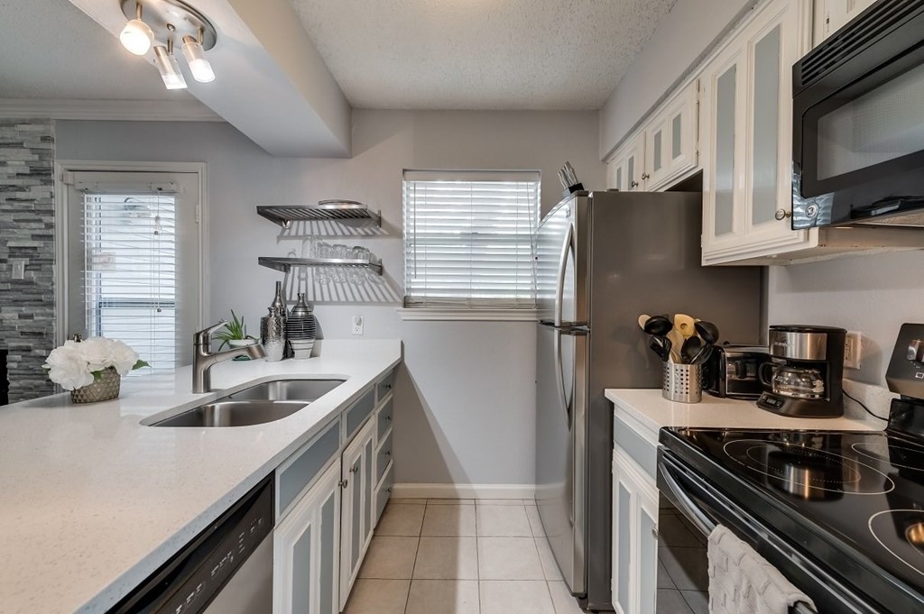 the kitchen has stainless steel appliances and white cabinets