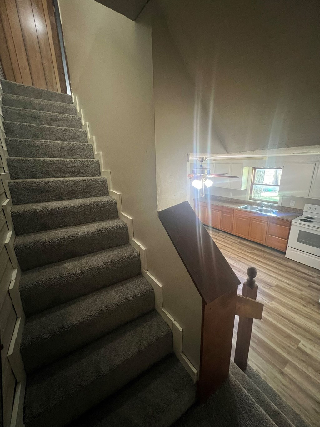 a view of the staircase from the bottom of the stairs looking up to the kitchen