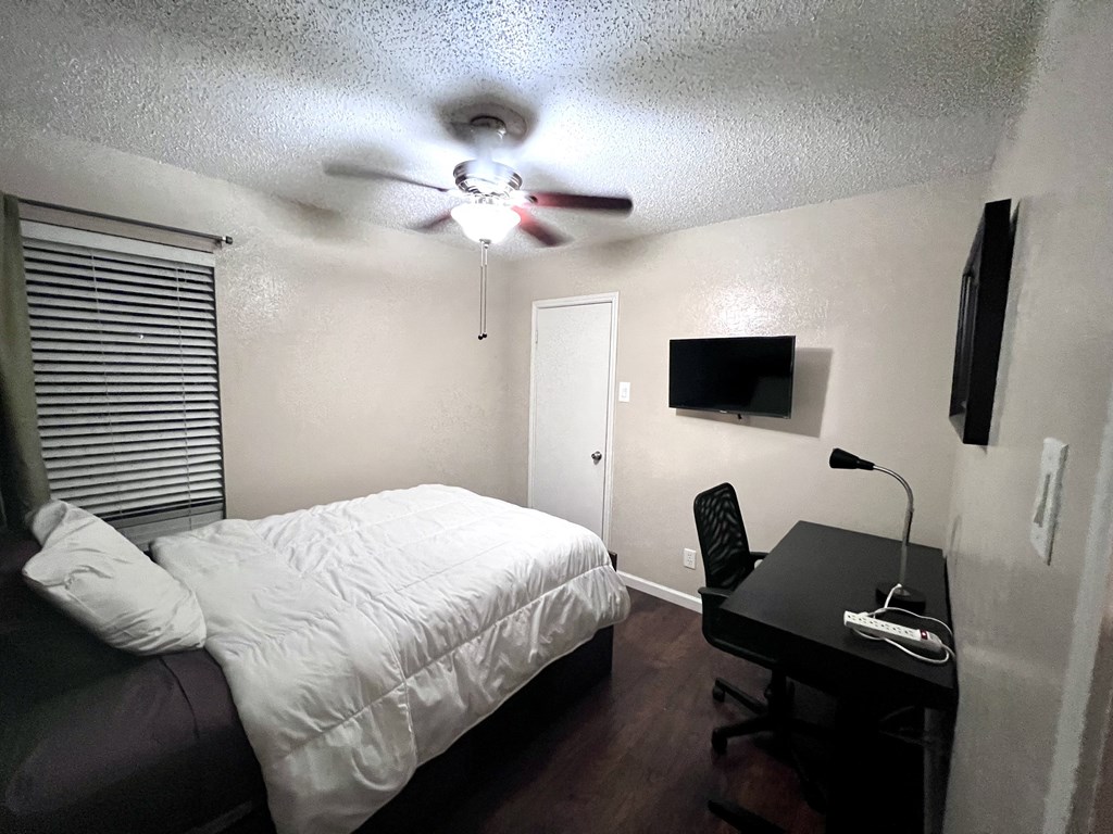 a small bedroom with a bed and a ceiling fan