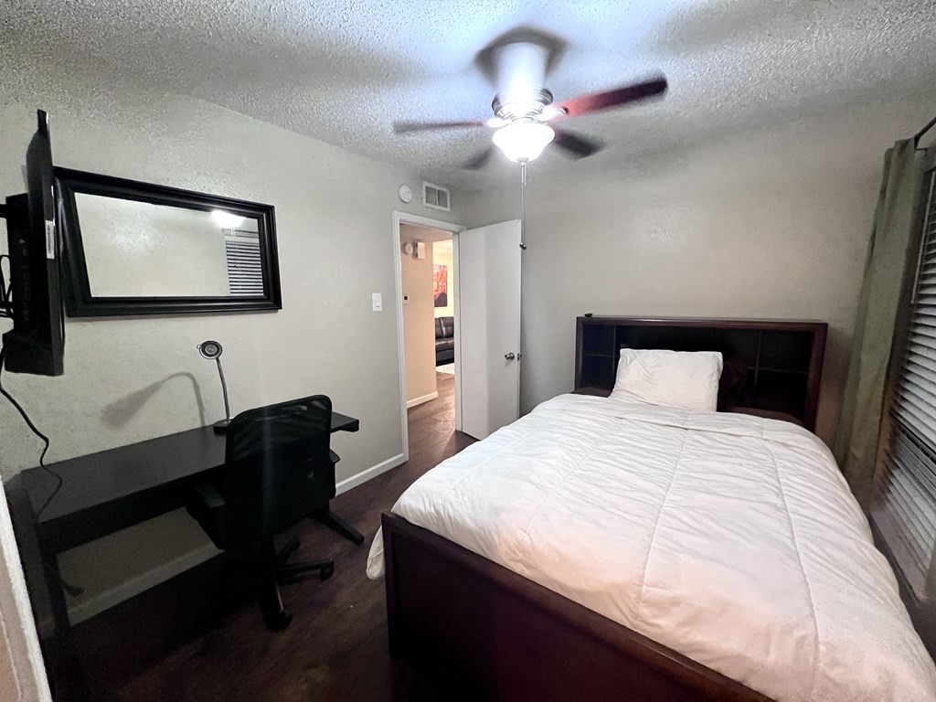 a bedroom with a large bed and a ceiling fan