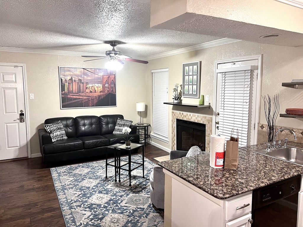 a living room with a kitchen and a couch and a fireplace