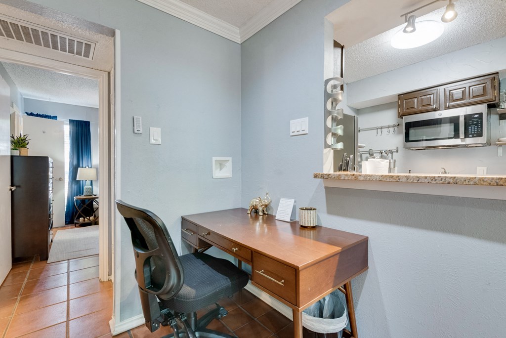 a home office with a desk and a microwave