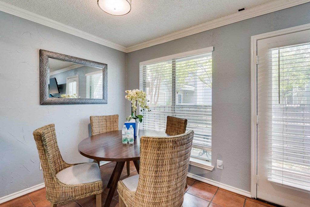 a dining room with a table and chairs and a window