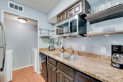 the kitchen is equipped with stainless steel appliances and granite counter tops