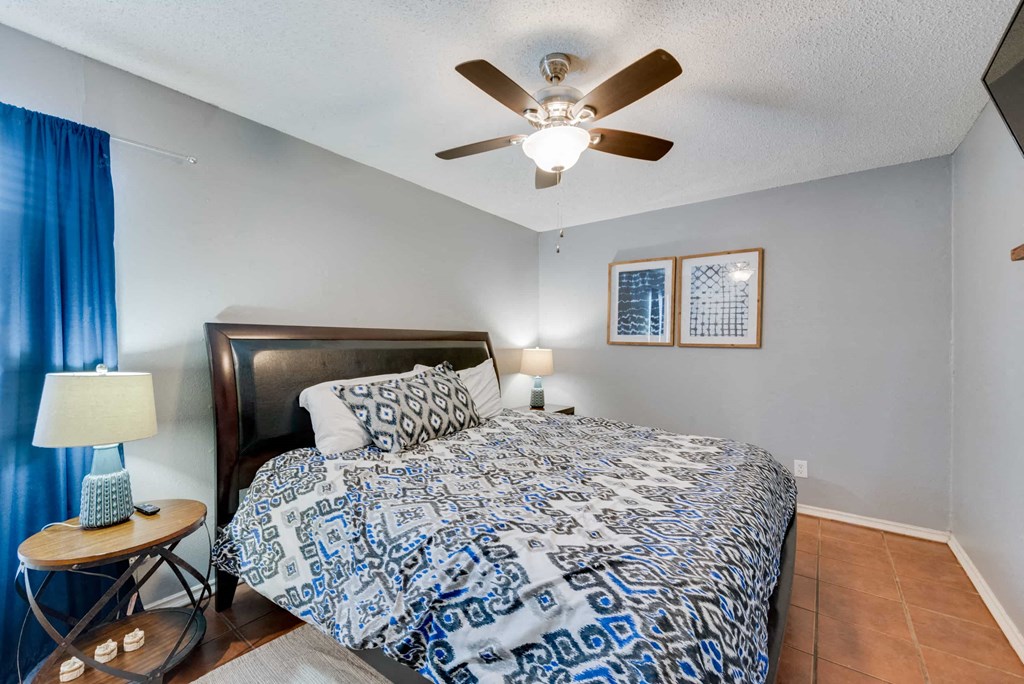 a bedroom with a bed and a ceiling fan