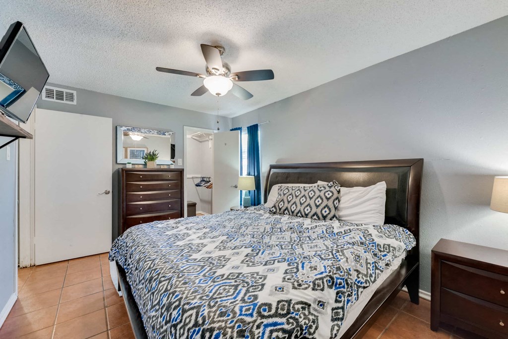 a bedroom with a large bed and a ceiling fan