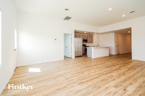 a renovated living room and kitchen with wood floors and white walls