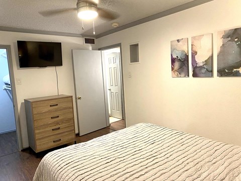 a bedroom with a bed and a dresser and a tv