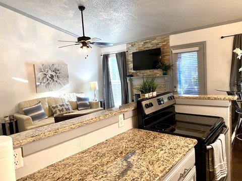 an updated kitchen with granite counter tops and a living room