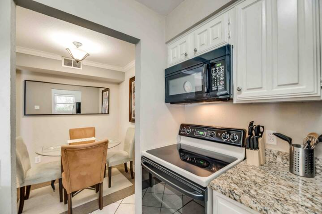 a kitchen with a stove and a microwave and a table