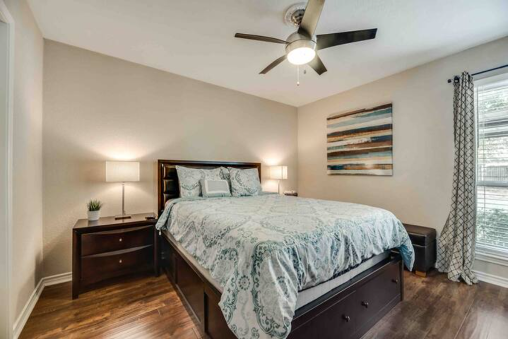 a bedroom with a bed and a ceiling fan
