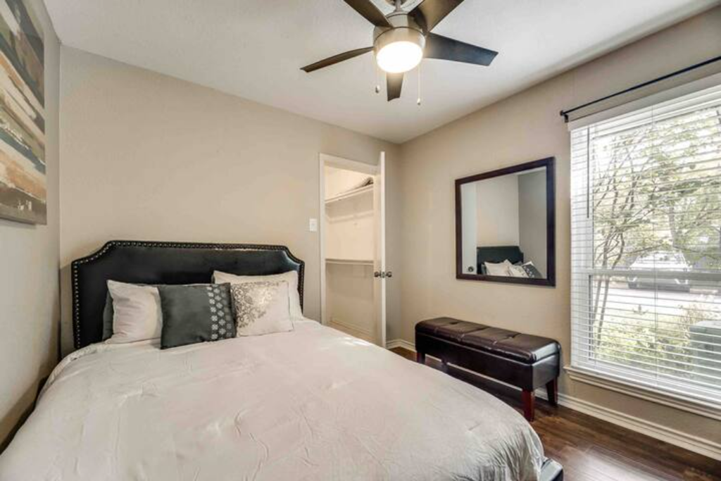 a bedroom with a bed and a ceiling fan
