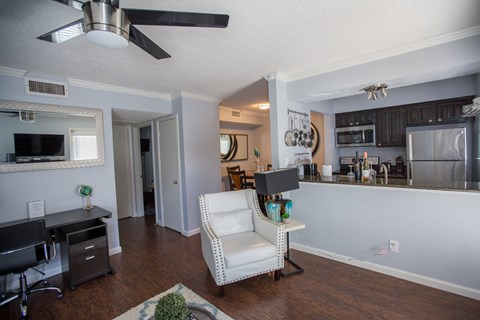 the view of a living room and kitchen with a desk and a chair