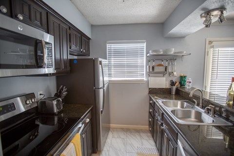 a kitchen with stainless steel appliances and black counter tops